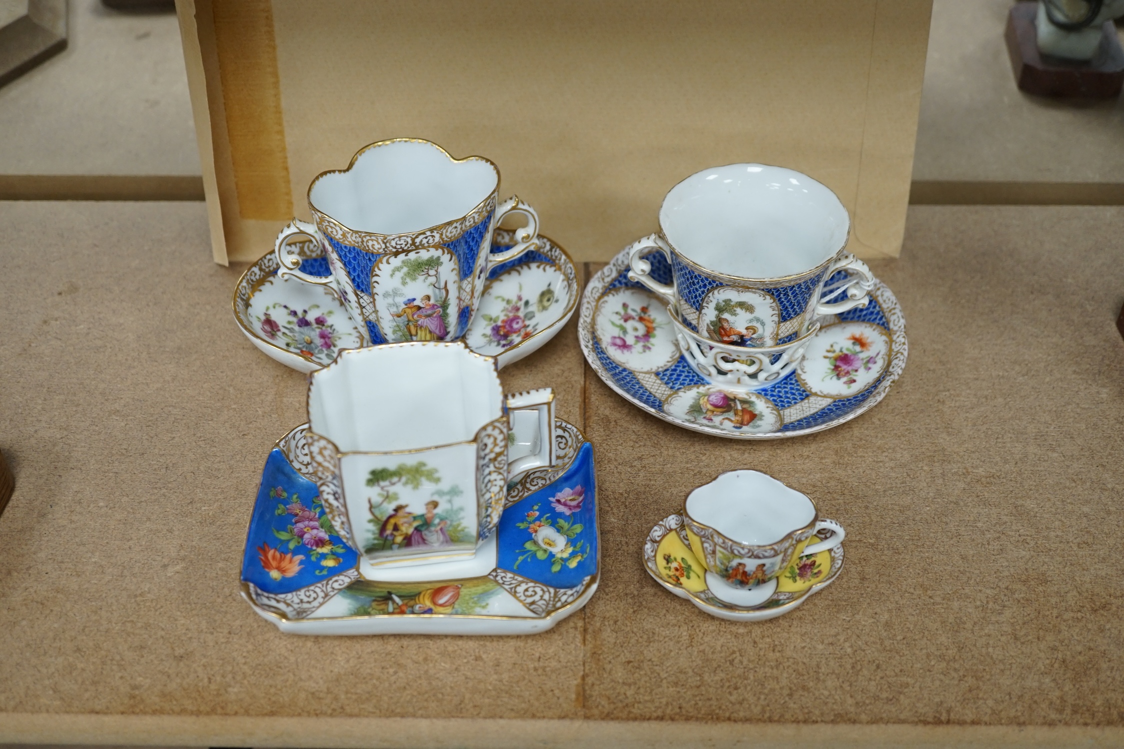 A Crown Dresden porcelain cup and trembleuse saucer, and three other Crown Dresden cups and saucers, largest 14.5cm wide. Condition - good